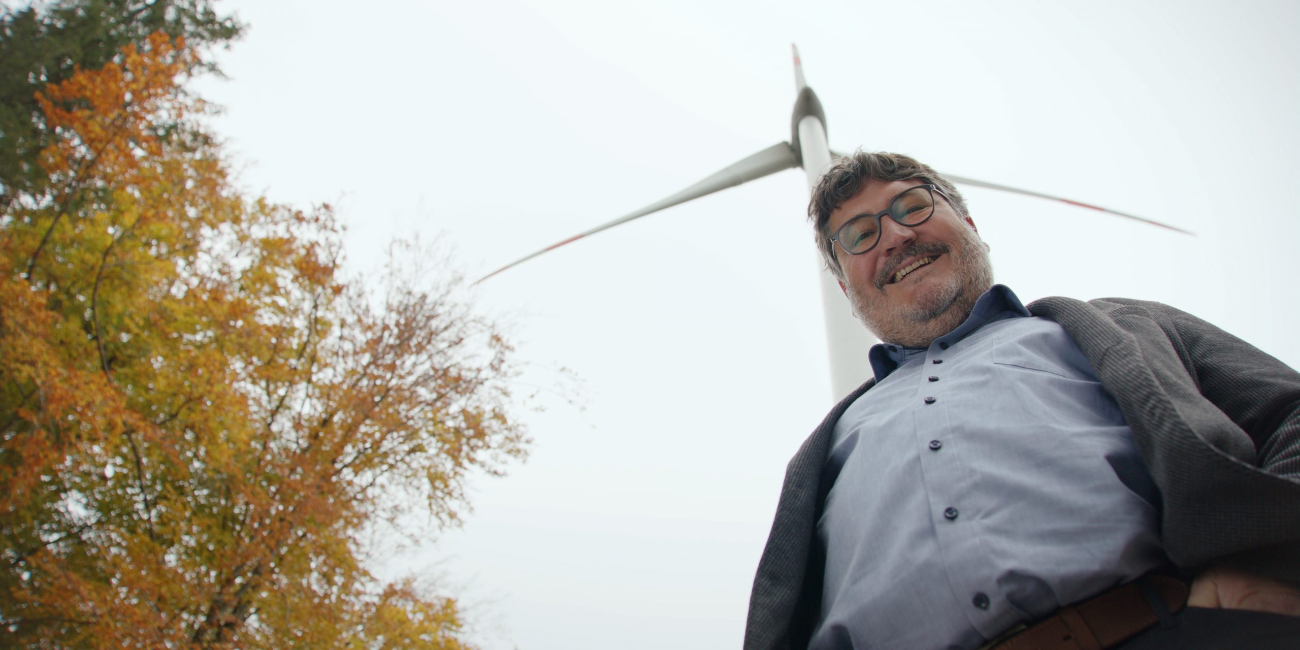 Foto von Bürgermeister Karg vor einem Windrad des Windparks Fuchstal.