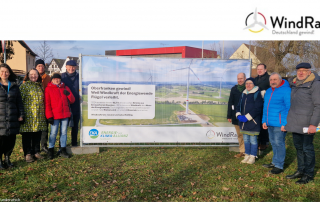 Auf dem Bild sind die Plakate der Kampagne zu sehen und diverse Vertreter*innen aus dem WindRat Netzwerk.