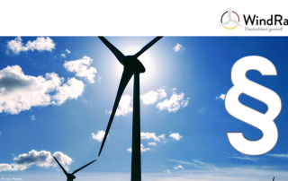 Auf dem Bild ist ein Windrat und ein Gesetzesparagraf zu sehen.