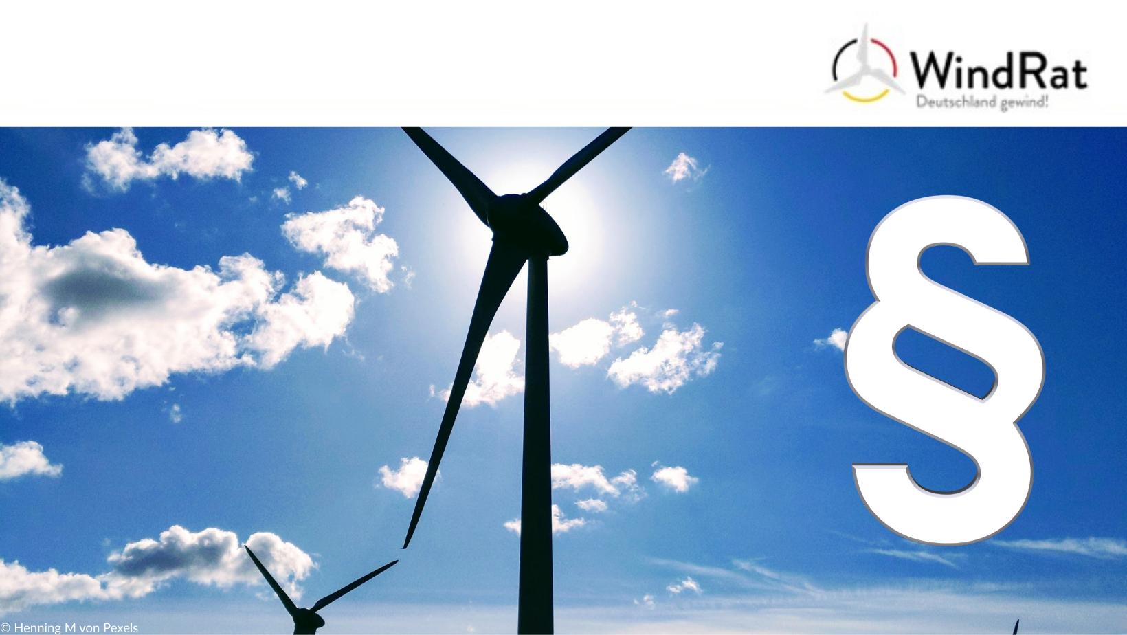 Auf dem Bild ist ein Windrat und ein Gesetzesparagraf zu sehen.