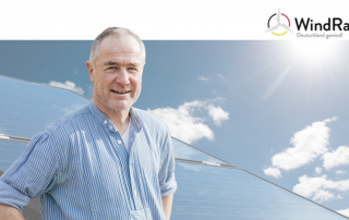 Auf dem Bild ist Peter Keller im Vordergrund zu sehen. Im Hintergrund sind Solaranlagen zu sehen.