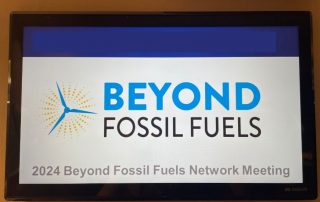 Man sieht ein Foto eines Schilds mit der Aufschrift "Beyond Fossil Fuels"