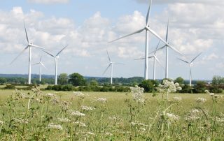 Man sieht Windräder als Symbol für Erneuerbare Energien im Einklang mit der Natur.